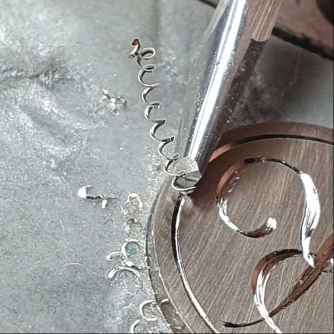 Raising a long curly burr whilst hand engraving a border on a silver pendant