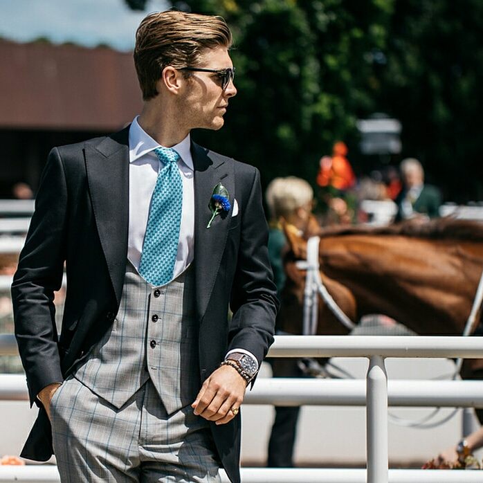 Gentleman in a three piece suit at the horse races wearing sunglasses and a signet ring