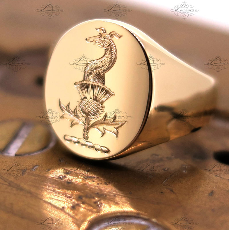 Surface engraved Crest on a yellow gold Oxford Oval signet ring.  Greyhound and thistle Crest.