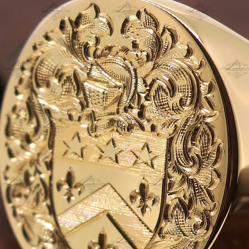Detailed close up photo of a surface engraved coat of arms on a yellow gold oxford oval signet ring