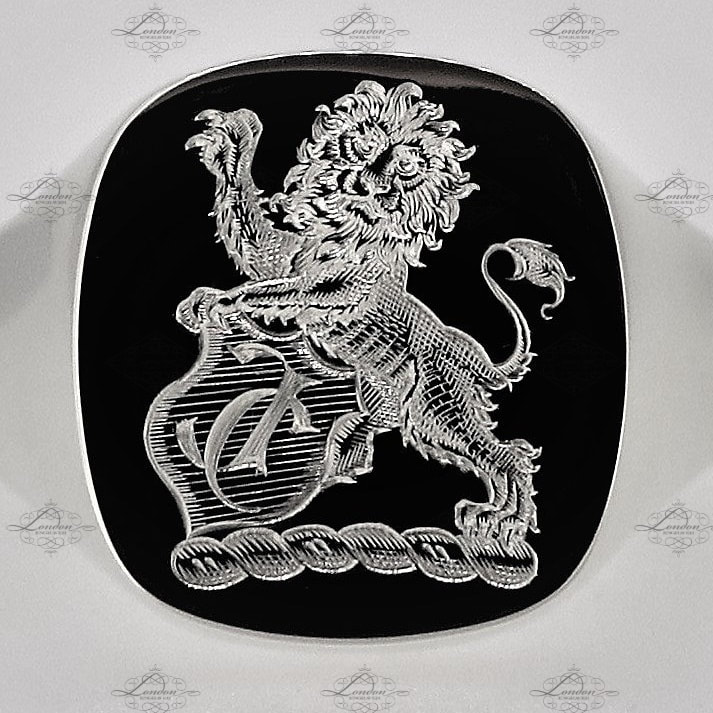 Lion crest holding a shield featuring custom initials, surface engraved on a white gold cushion signet ring