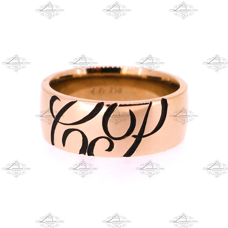 Initials CP engraved on the outside of a rose gold wedding band, with black enamel