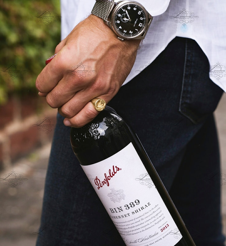 Man holding a bottle of Penfolds red wine, wearing a signet ring, Bin 389 Barossa Valley South Australia