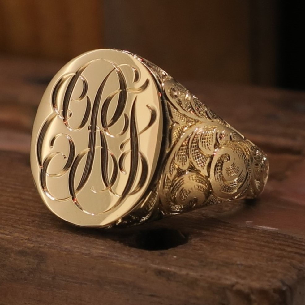 Custom design script monogram ERF on a yellow gold signet ring, with hand engraved scroll pattern on shoulders